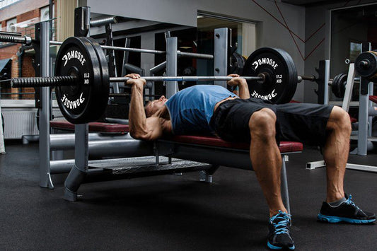 Man doing bench press with bumper plates