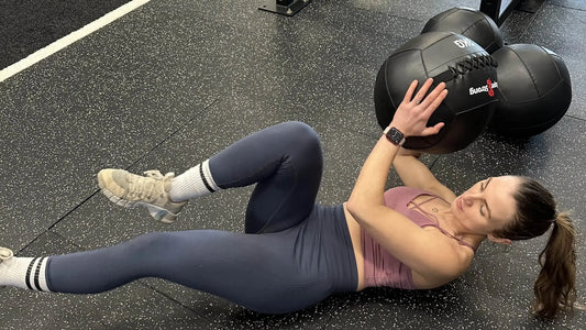 female performing medicine ball exercise