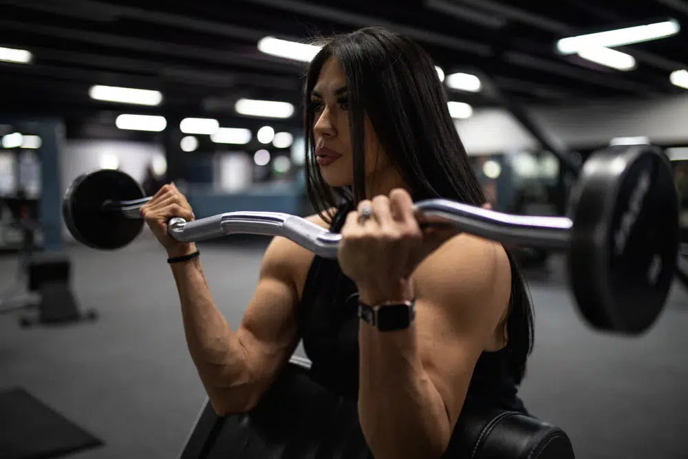 Women performing a preacher curl on apreacher bench