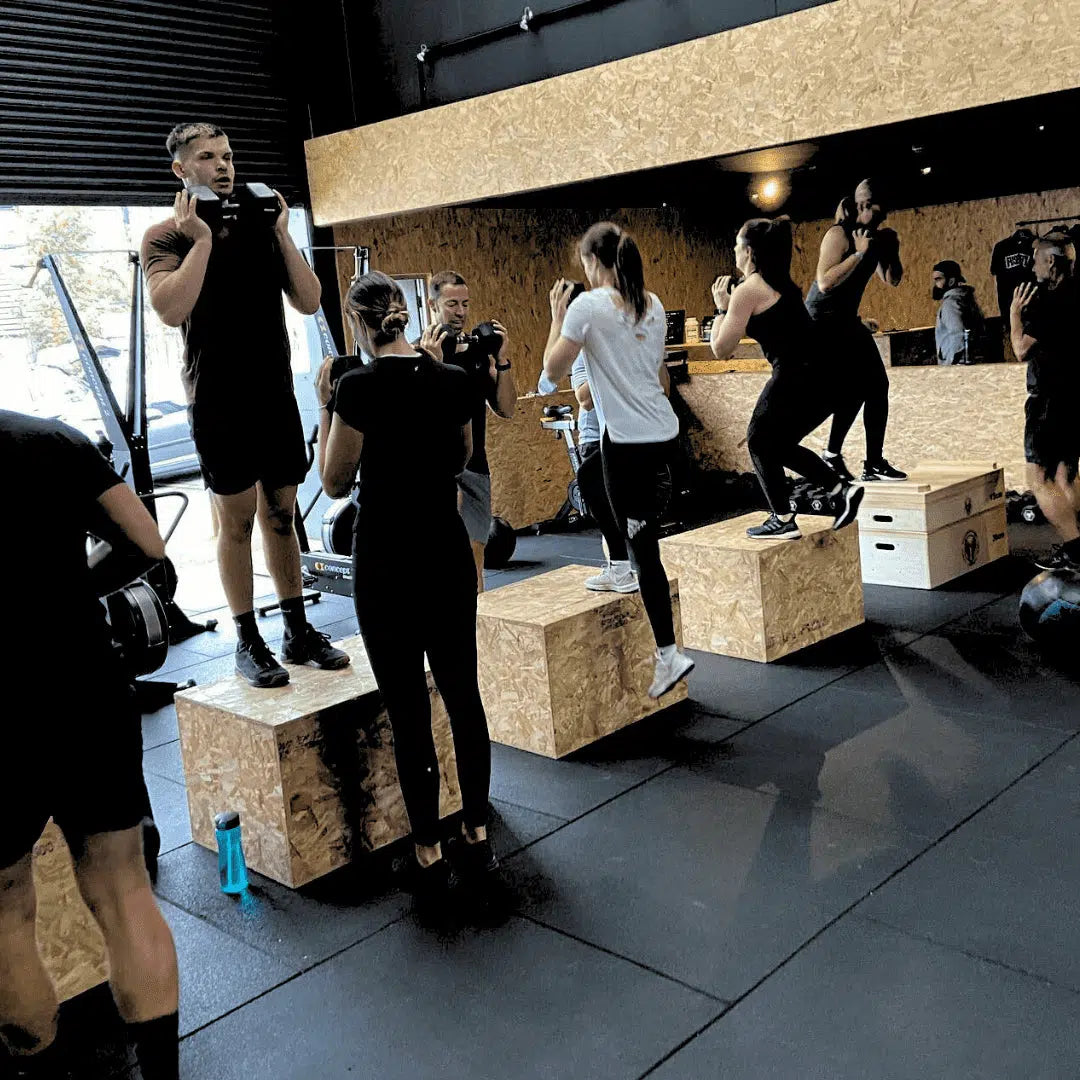 Group fitness session with ooden plyo boxes on 20mm gym mats