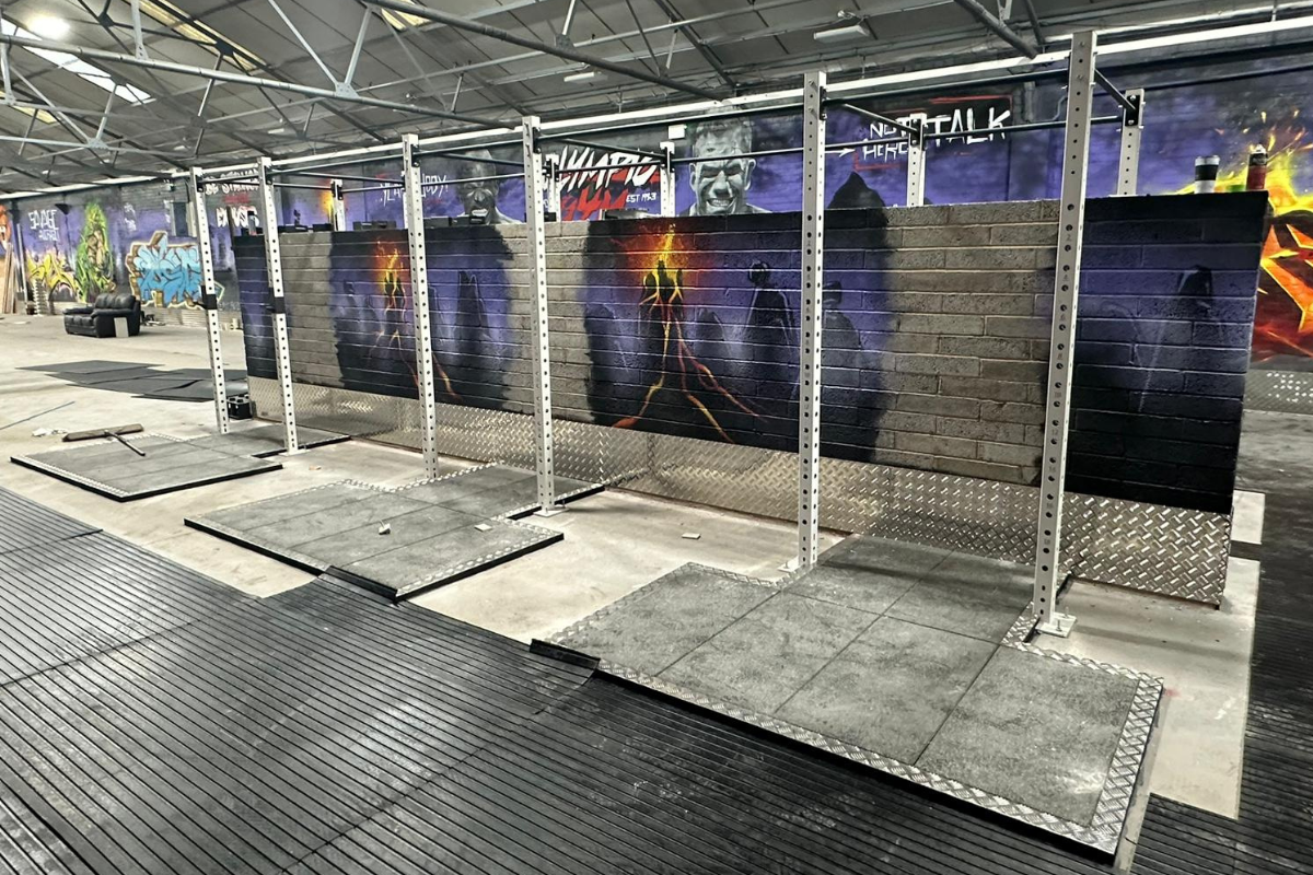 Photographs of a white gym/crossfit rig ina a gym which is decorated with graffiti wall art